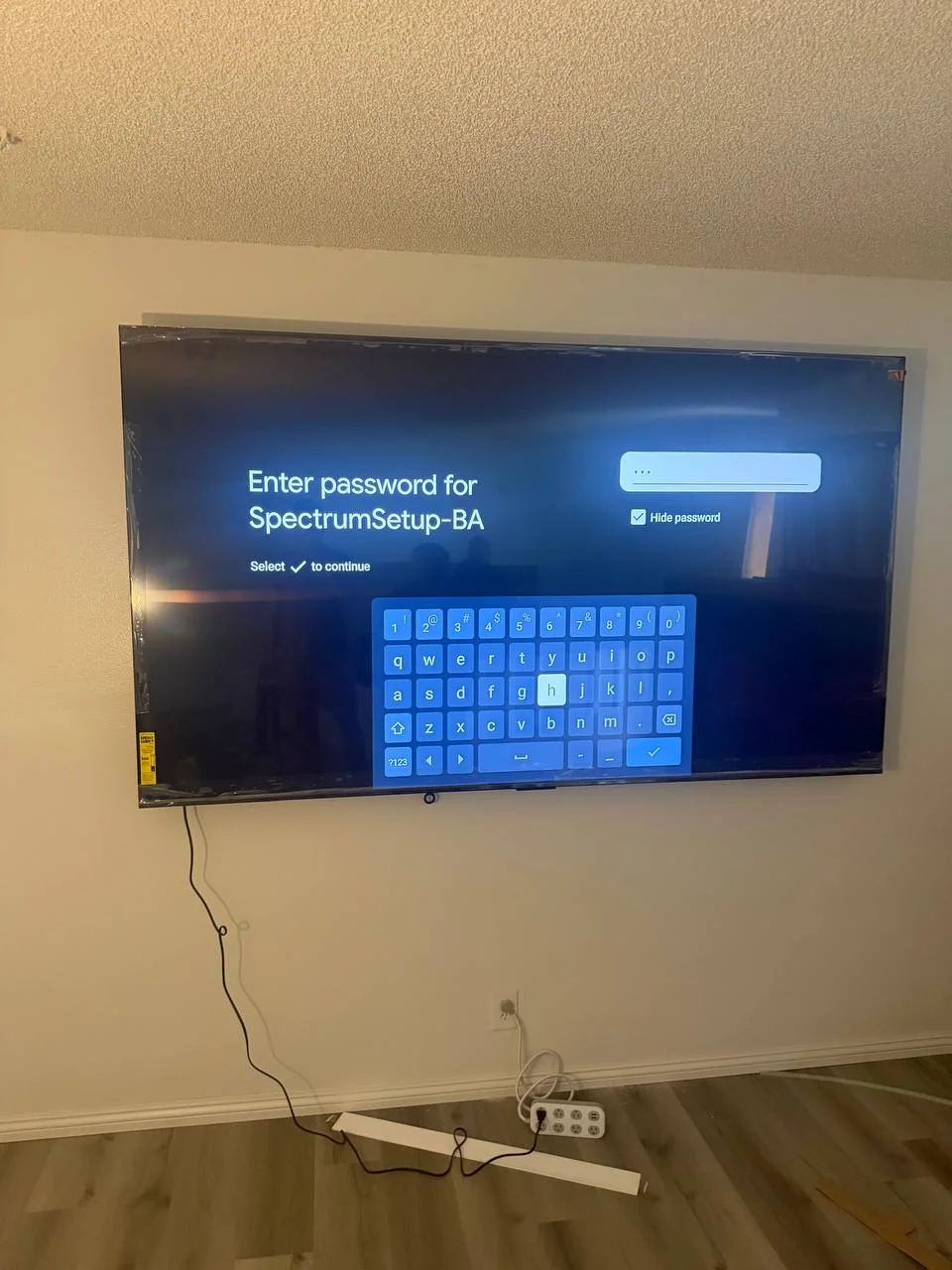 86 inch TV mounted on textured drywall with full motion bracket in Los Angeles living room